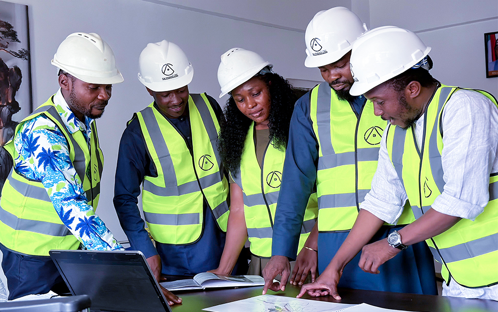 A team in safety gear reviewing plans together