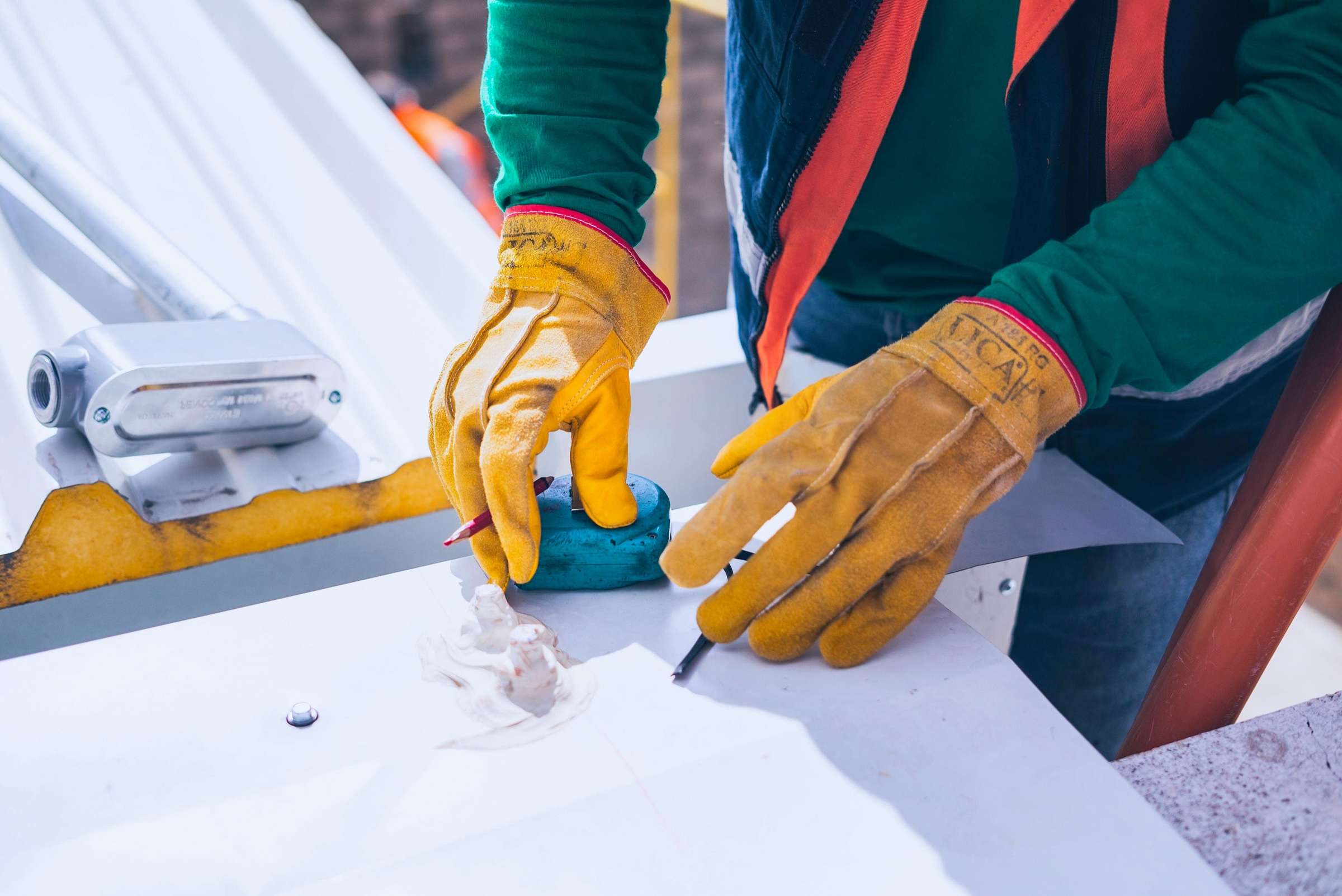 A worker measuring and inspecting a finished steel sheet